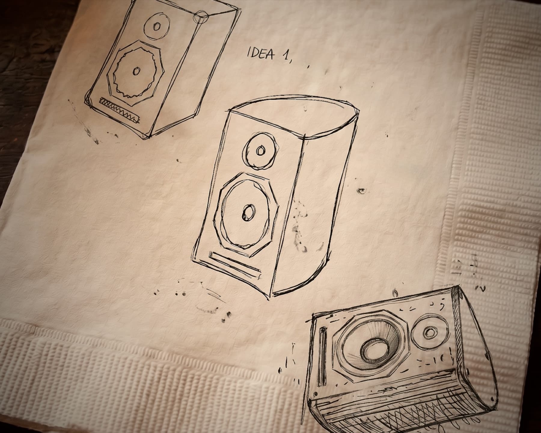 Bocetos a tinta de tres cajas acústicas sobre una servilleta