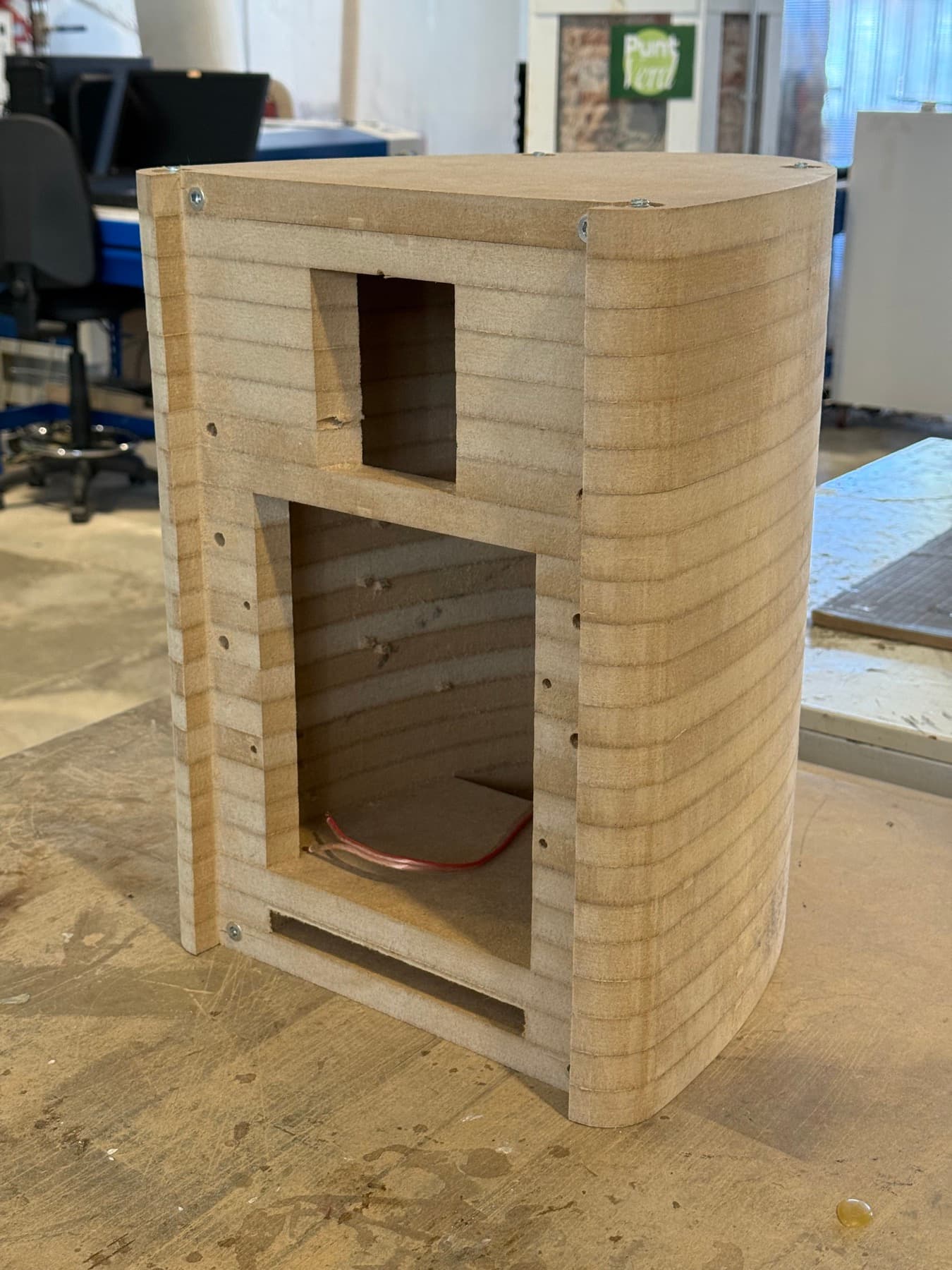 Caja de capas de MDF apiladas sobre un banco de taller, sin frontal